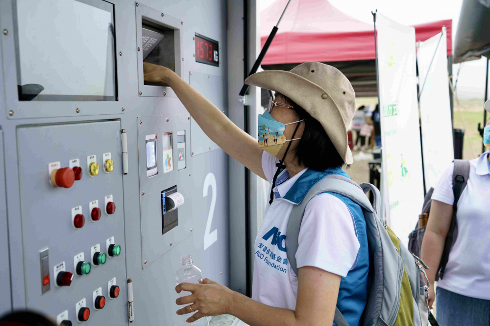 志工們將拾起的寶特瓶投入「好歸塑專車」，讓廢棄塑料空瓶可以直接粉碎、縮小體積，未來將可再製成購物袋、寶特衣、悠遊卡等生活用品
